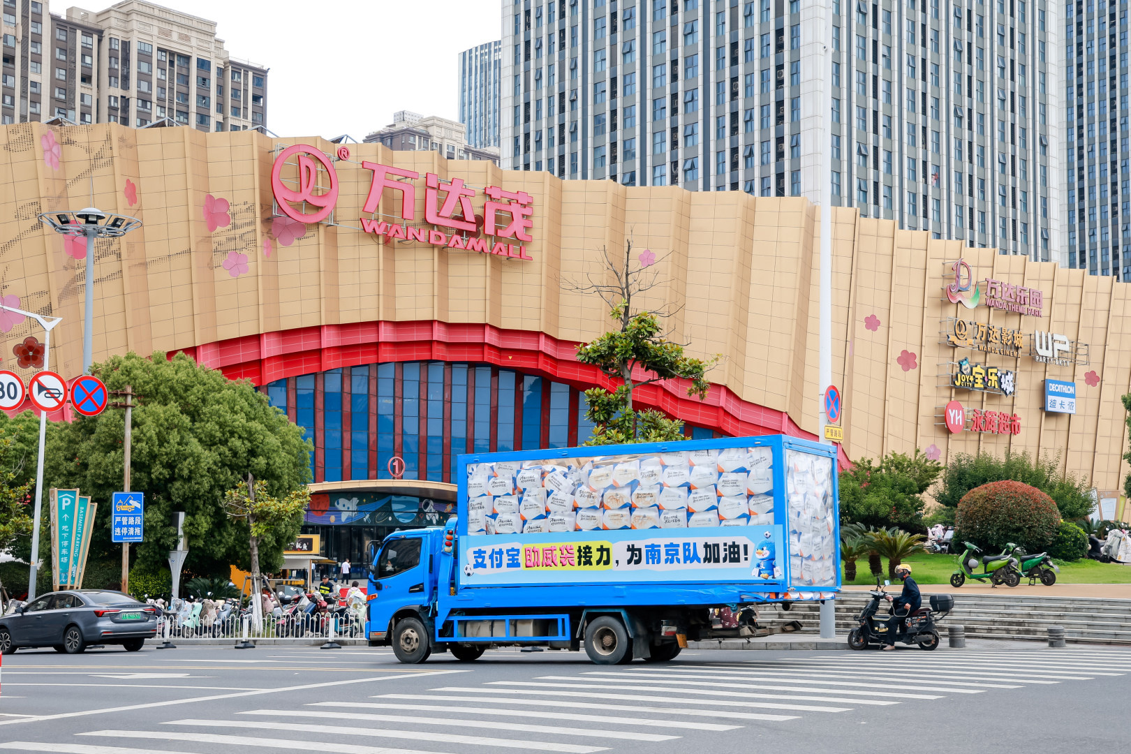 百店发支付宝助威袋为南京队加油支付宝带来十万份“苏超”助威袋落地南京，运输车辆穿