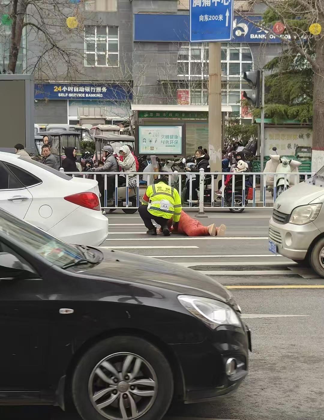 今天下午，荥阳万山路与索河路路口上演暖心一幕。一位老人横穿马路时不慎摔倒，头部受