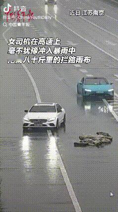 积德了！南京，女子冒雨下车拖拽80多斤雨布，暖心举动避免后车急刹造成事故。她说：