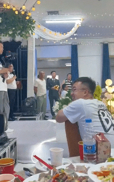 这个男子应该是在自己的新婚典礼上，手持鲜花准备迎接新娘，在这么神圣庄严温馨浪漫的