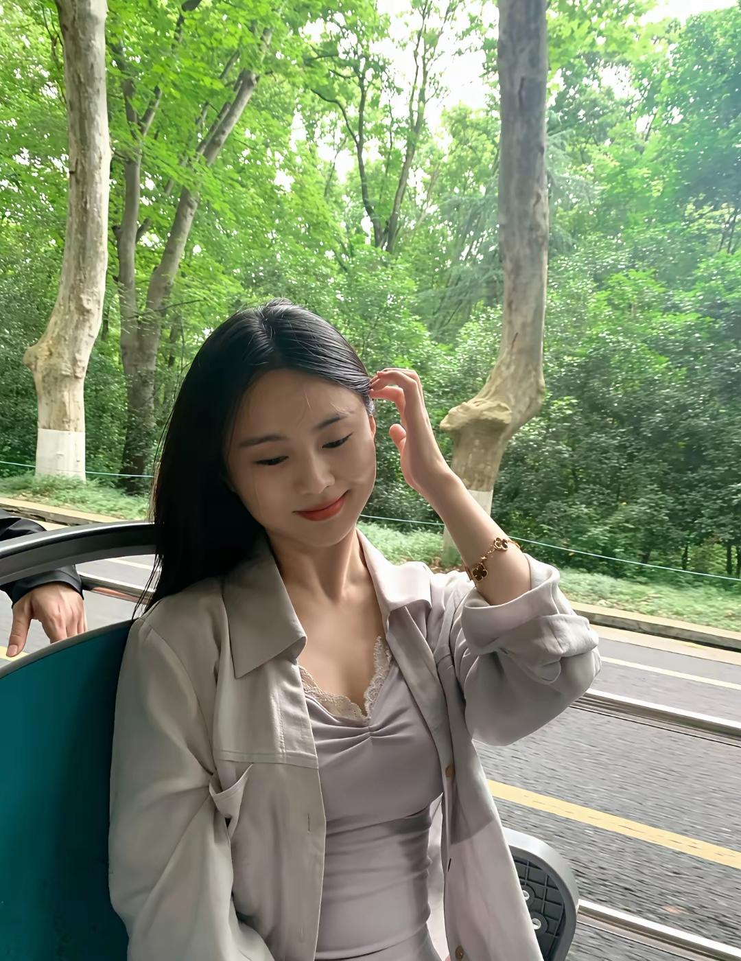 阳光明媚，她坐在公交车上。