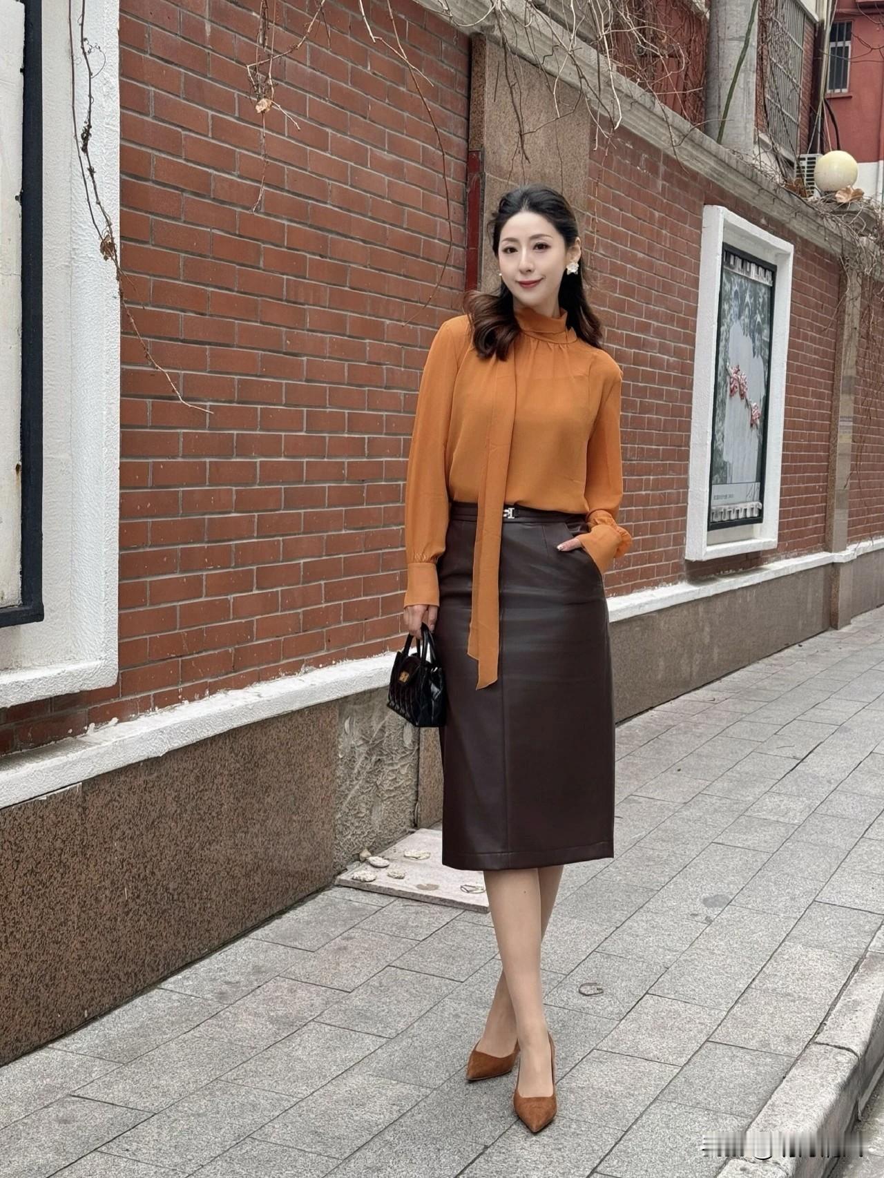 橙色衬衫配棕色皮裙，这组合也太好看了吧！

以前总觉得橙色不好驾驭，没想到搭上棕