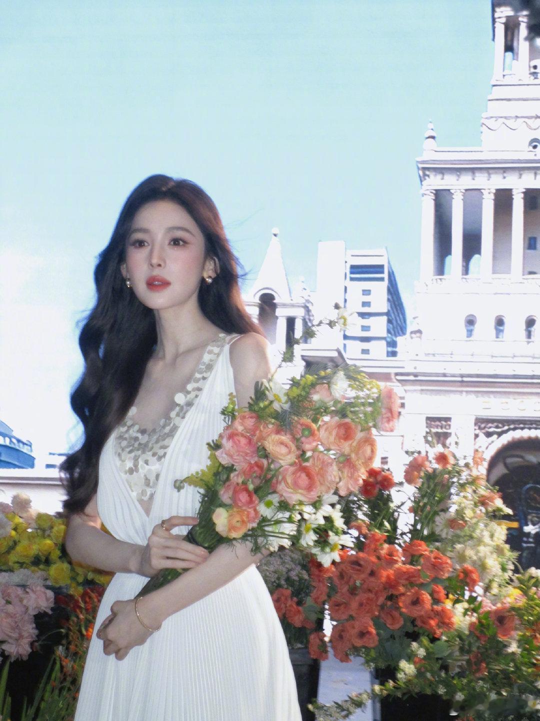 娜扎一转身春天到了 娜扎手捧鲜花清新明媚，一身白色亮片连衣裙春日感拉满，风吹发丝