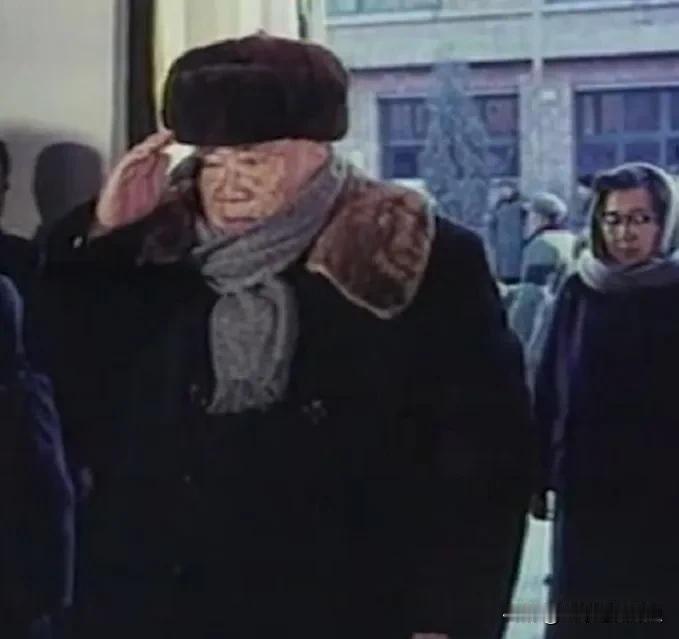 寒冬萧瑟之中，这一幕令人为之动容。年迈的朱老总身着厚重冬装，郑重抬手敬礼送别周总