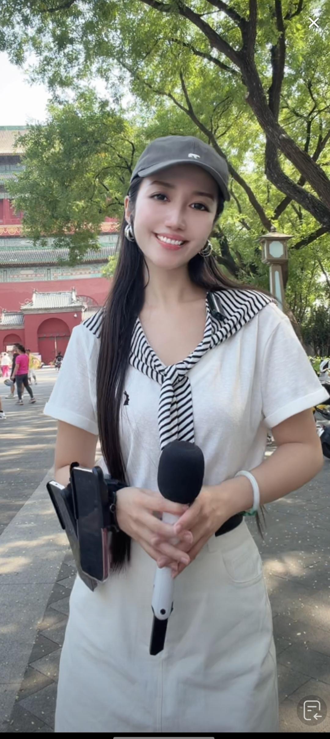 这位小姐姐在户外采访呢。