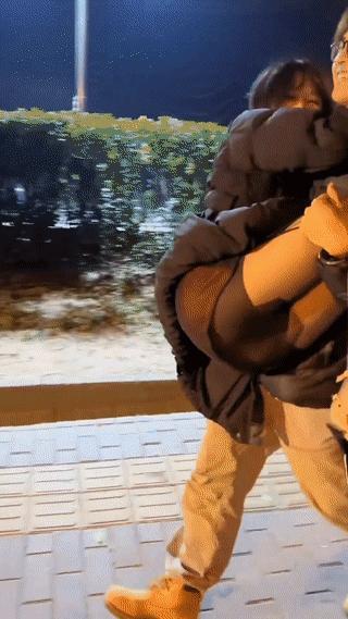 一名男生深夜接在夜场上班的女朋友下班回家。
只见他抱着女朋友在街头行走，两个人看