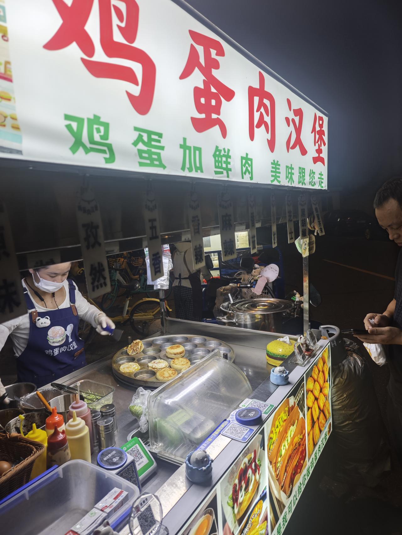 夜里散步看见一家鸡蛋肉汉堡小摊，烟火气一下子拉满。招牌写着鸡蛋加鲜肉的汉堡，一个