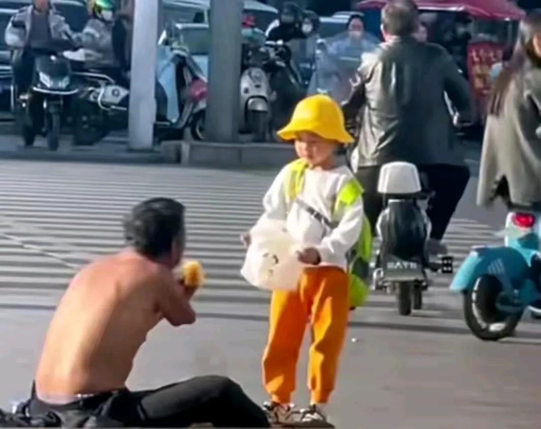 温馨的一幕！大街上烈日当空，只见一个大约五岁左右的小男孩手里拿着两个面包，跑到在