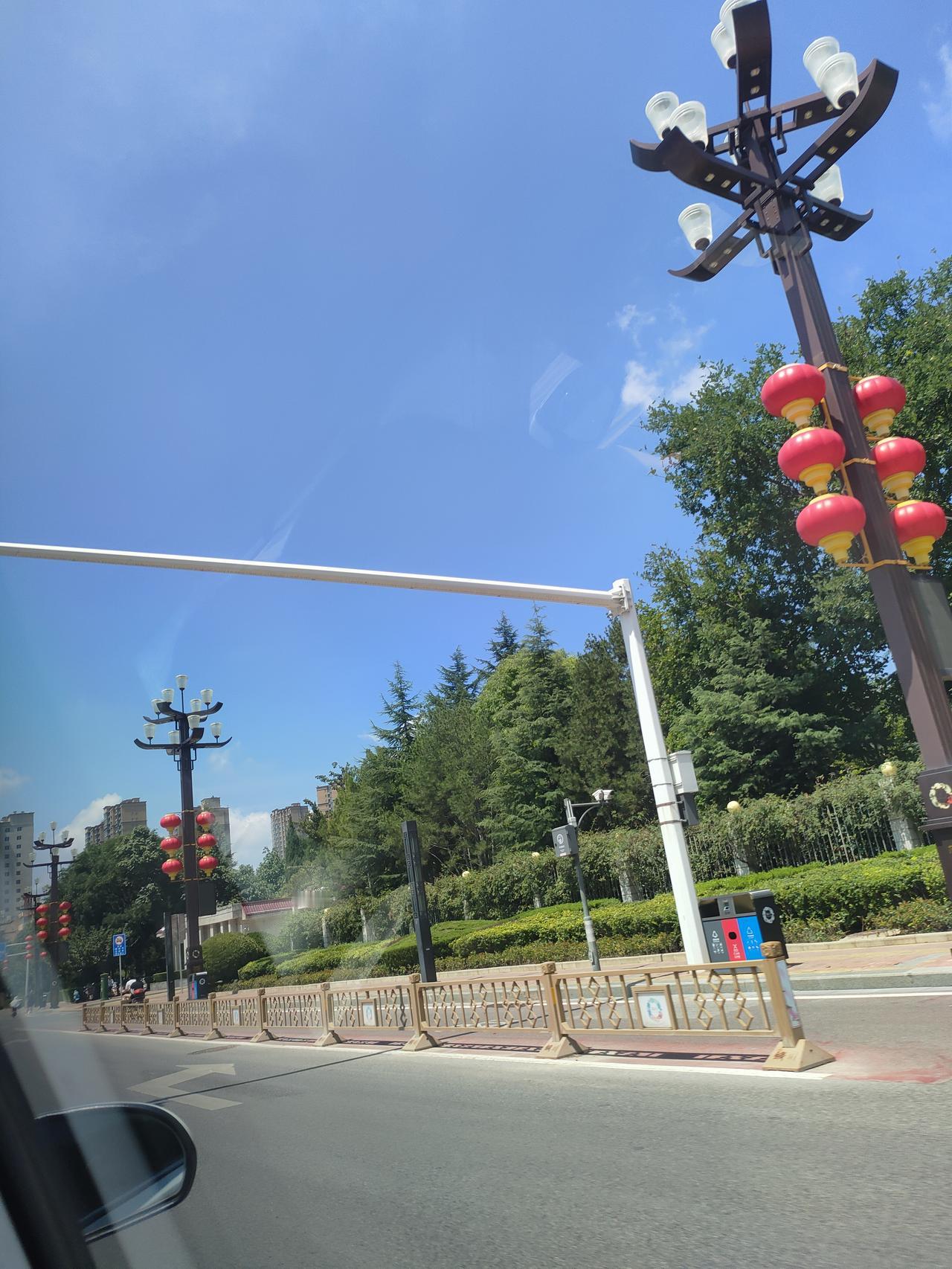 晒图笔记大赛车行小城街道，绿树成荫，红灯笼点缀路旁，晴空万里，处处都是家乡独有的