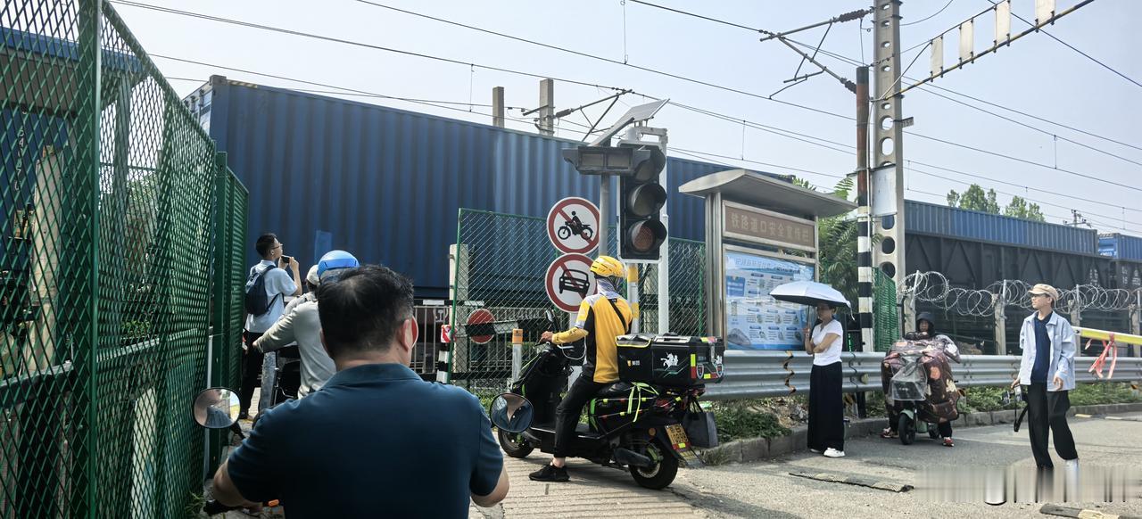 北京五环内，还有这样的铁路道口，时常有列车经过，行人们在静静等待