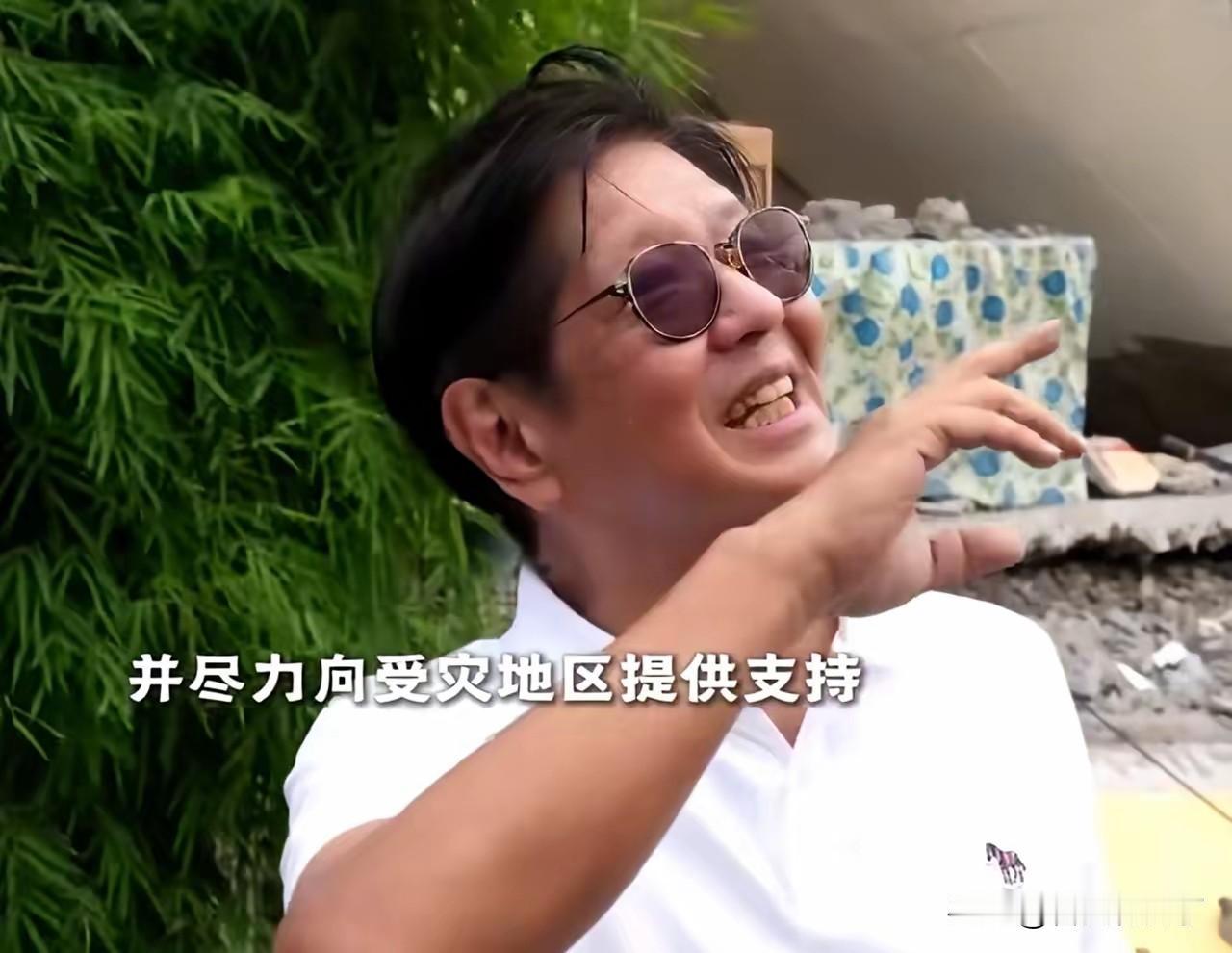 菲律宾总统小马科斯站在灾后的废墟上接受采访，脸上布满了发自内心、由衷高兴的笑容，