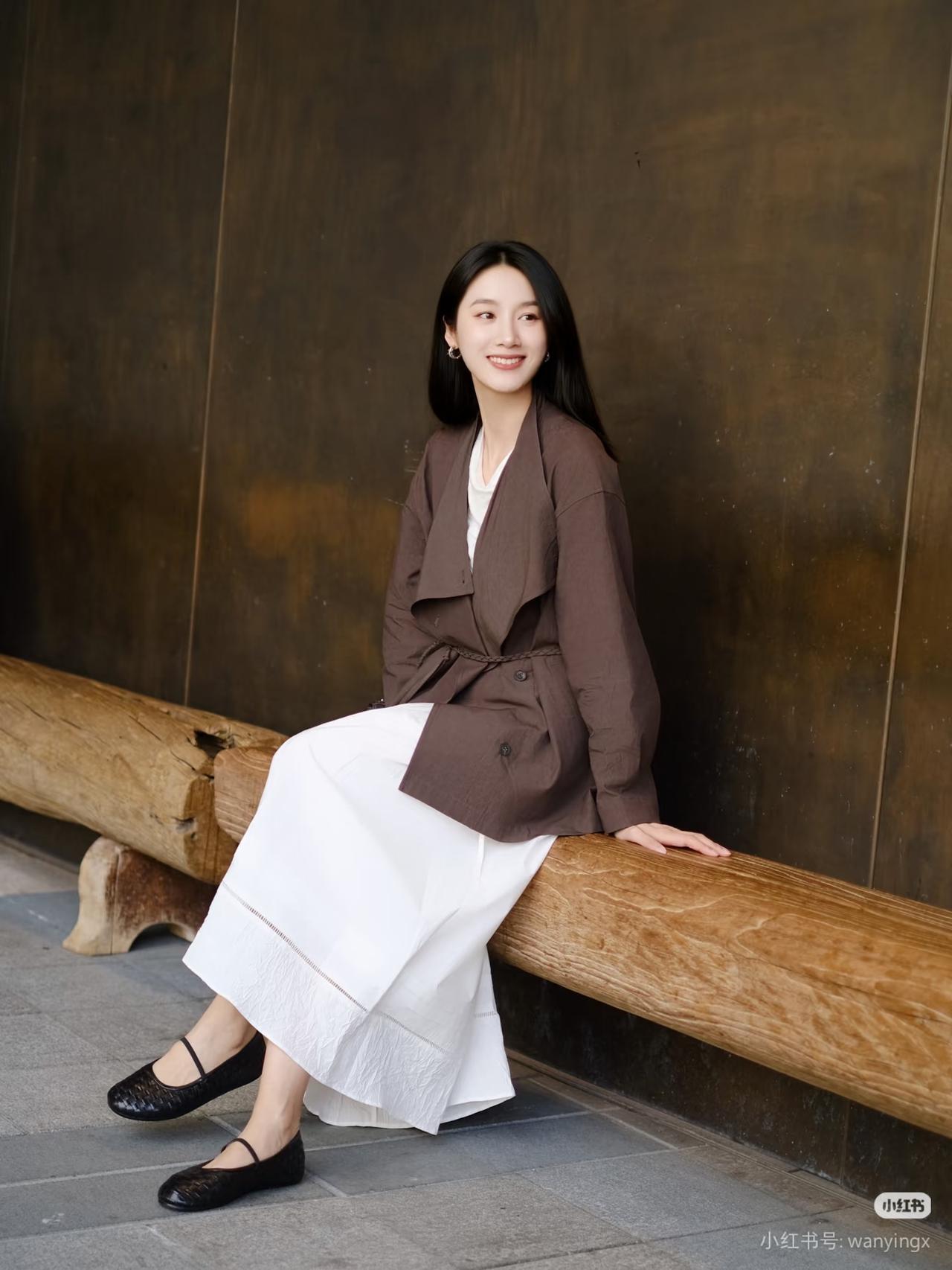 一个女孩靠在木头上微笑。