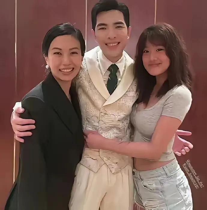 贾静雯的大女儿梧桐妹，跟萧敬腾夫妇合影。
梧桐妹穿着暴露，紧贴着萧敬腾，一只手还