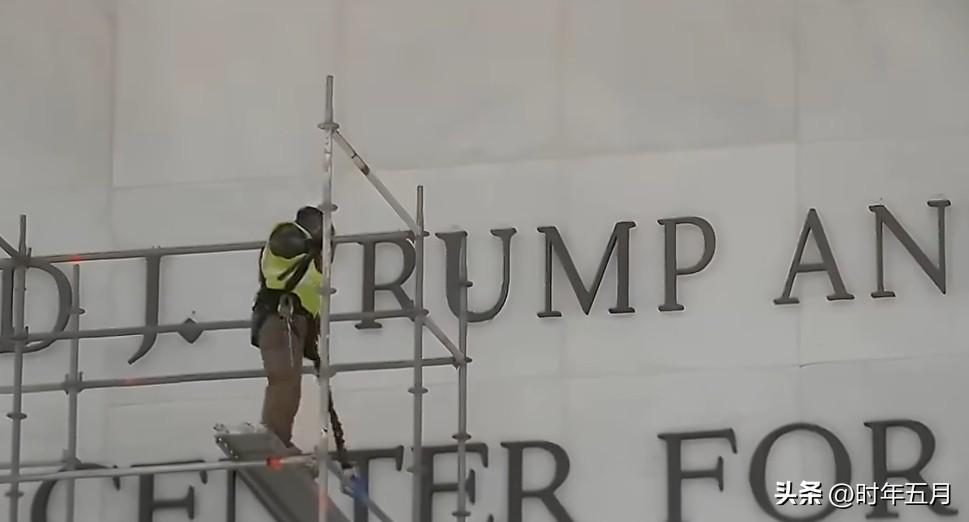 工人们搭建脚手架，准备拆除肯尼迪中心建筑上的“特朗普”字样，现场有人开始欢呼。