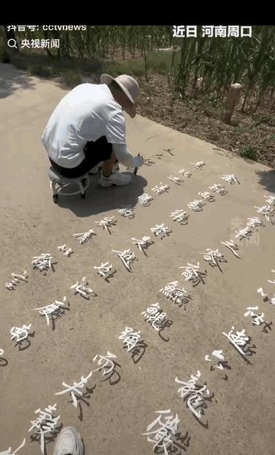 终于火到央视了！”在河南周口，一名男子不惧酷暑，每天坐在田间水泥路上，用黑白颜料