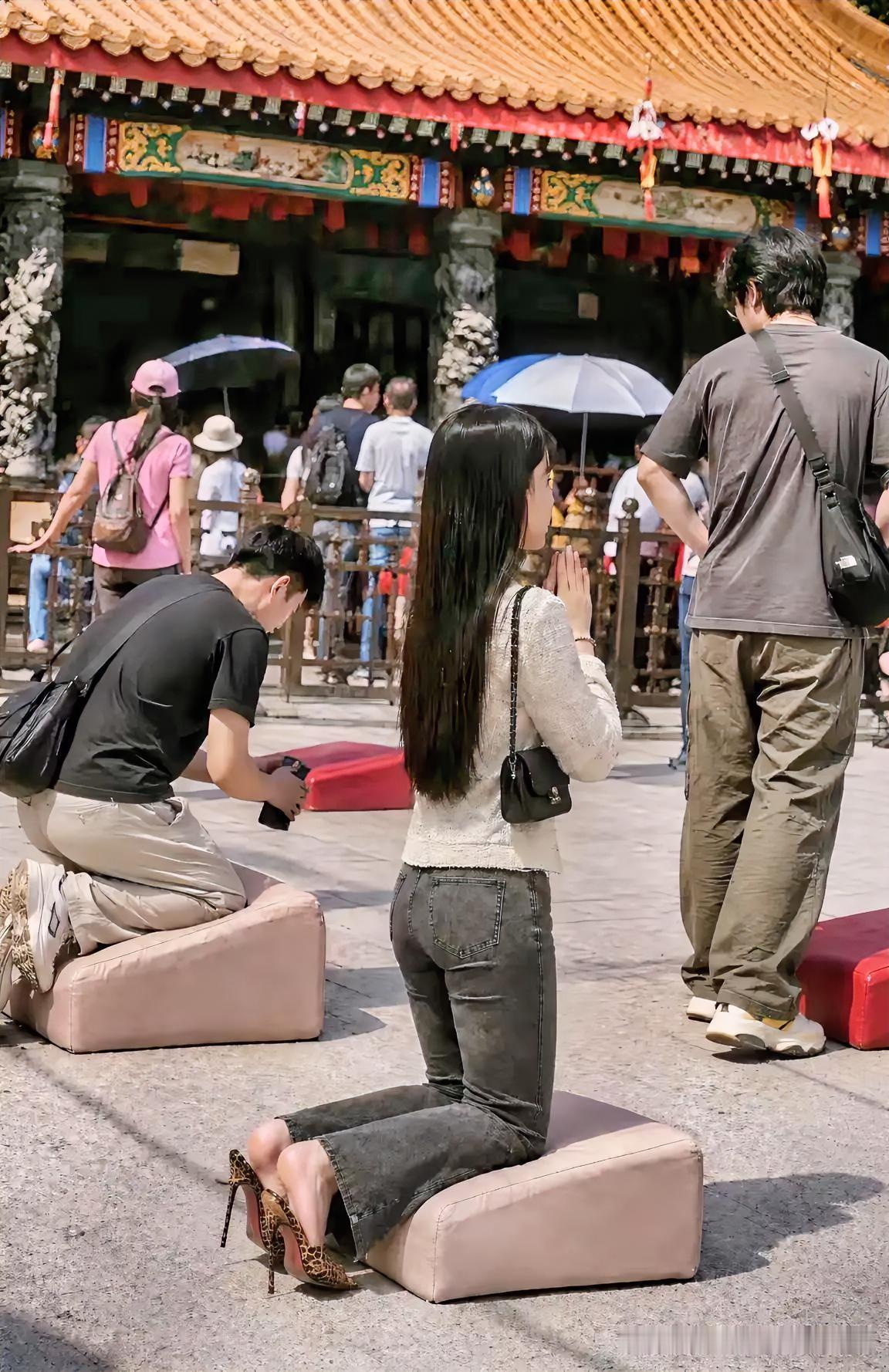 古刹殿前的香火气里，穿细高跟的姑娘跪上香垫，双手合十对着殿宇闭着眼默念。谁都看得