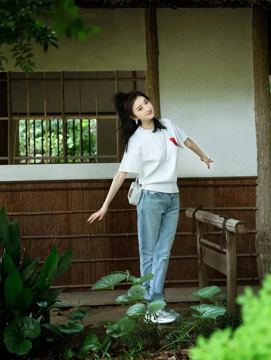 人间富贵花景甜的基础款穿搭。

一件基础款白色体恤搭配小脚牛仔裤，脚踩运动鞋，简