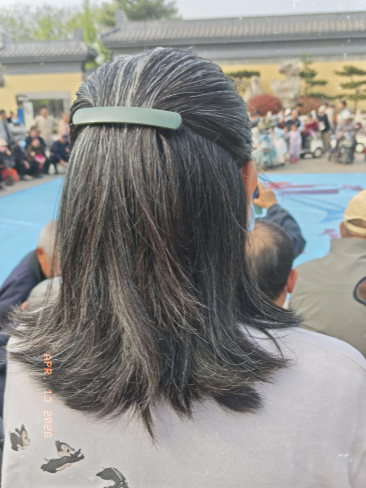 上周六下午，陪小姨去赵苑公园南门看演出。
站在我们前面一位女观众，头发已经掺杂了