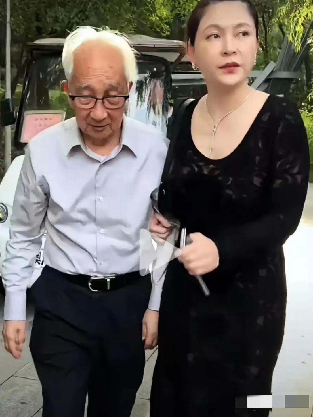 镜头中91岁的中央美院老院长靳尚谊白发稀疏，眉毛花白，已弯腰驼背了；而46岁的妻
