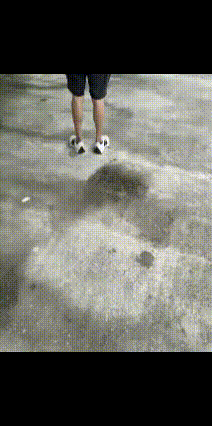 一男子拿着水枪，到处寻找目标。他看到有个吸烟者，正在等红绿灯。悄悄的走上去，然后