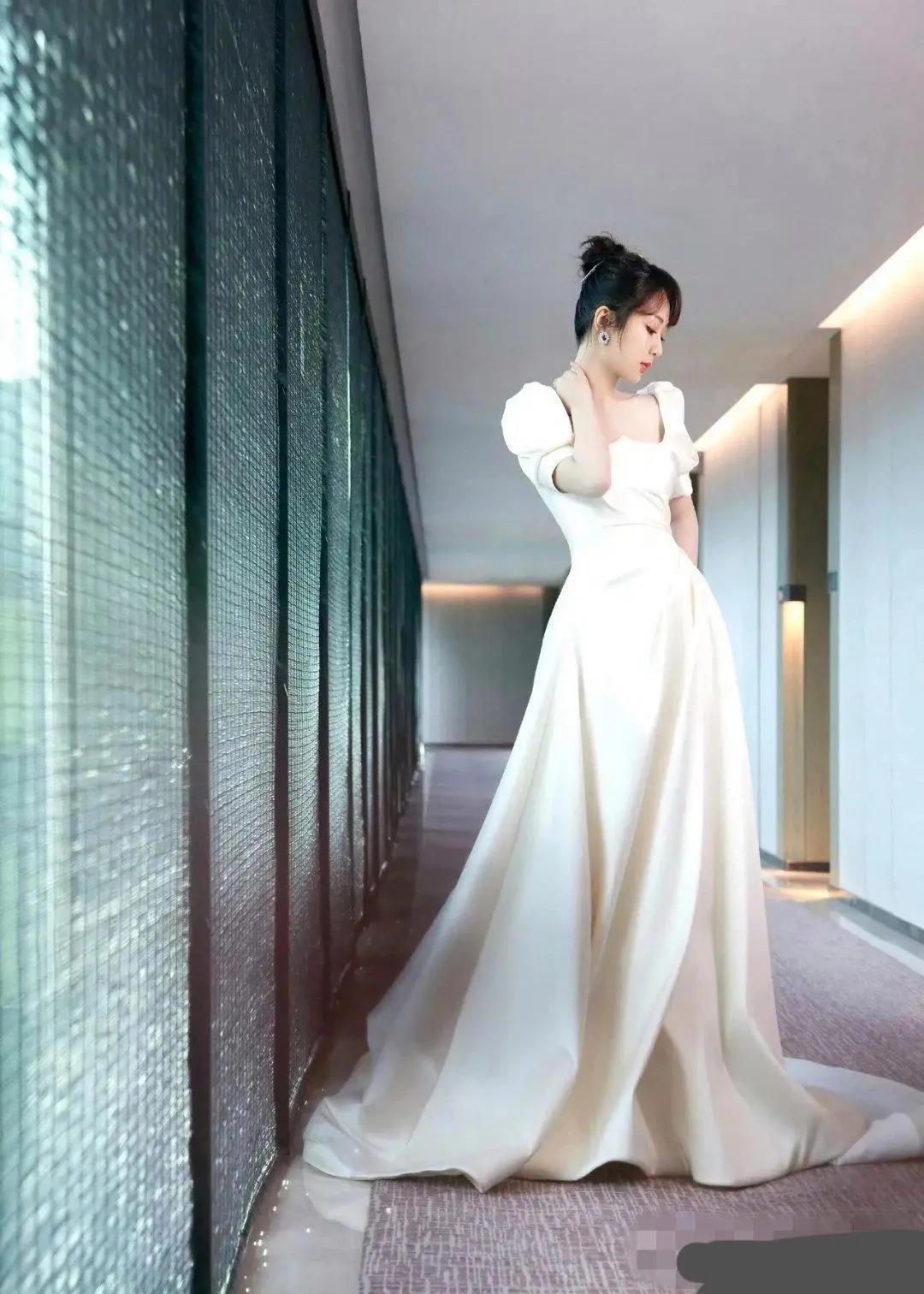 杨紫，身着米白色拖地礼裙，犹如高贵的白天鹅，高丸子头俏皮又不失优雅。