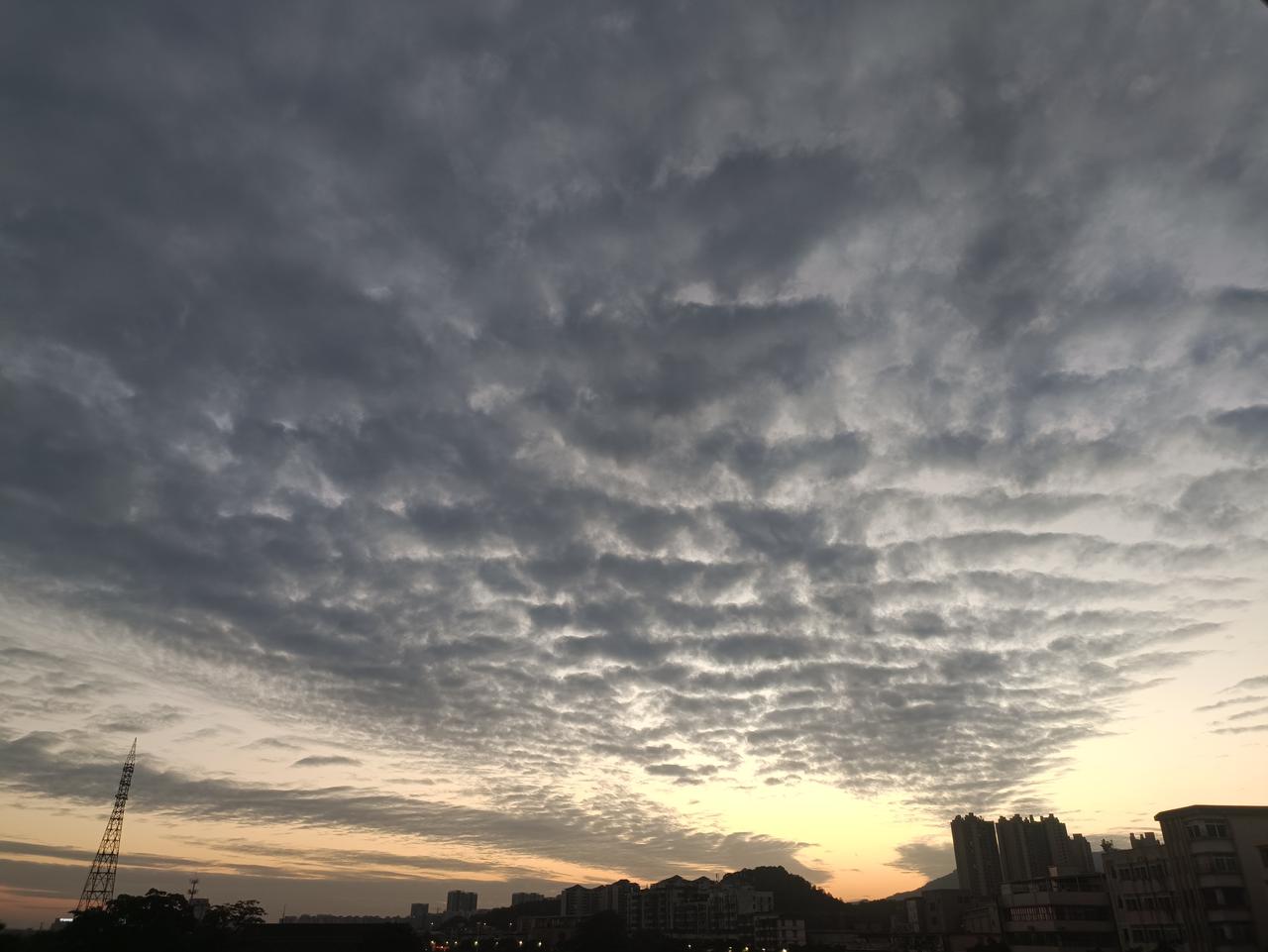 也不算乌云密布，
但却有黑云盖顶。
夕阳下的天空，
似有龙腾虎跃的霸气。