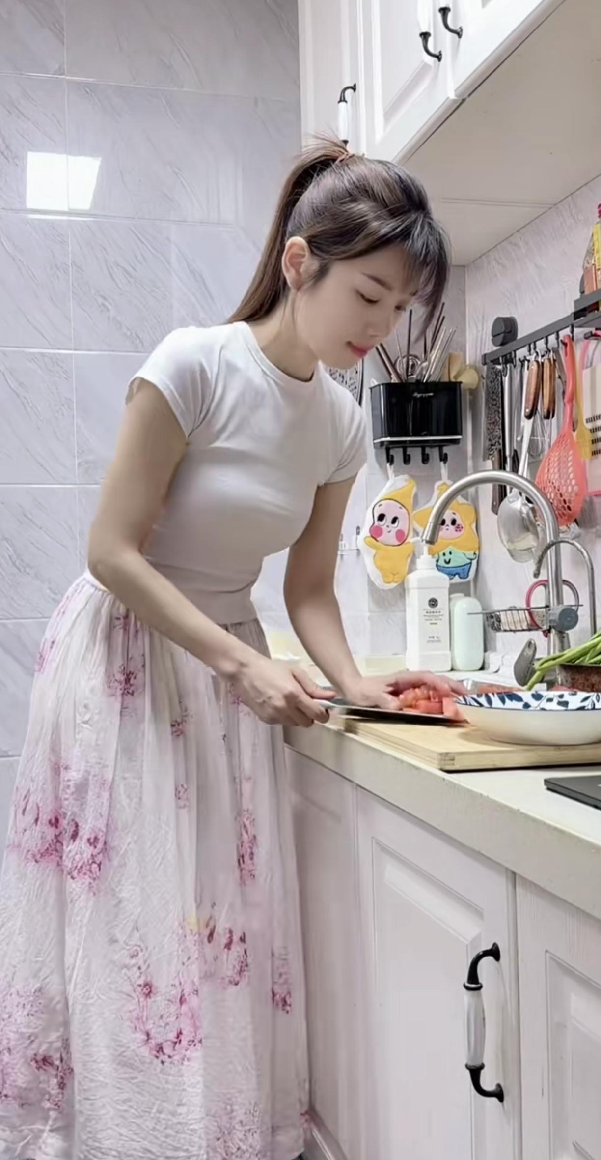 这位是抖音美食博主静如此可爱呀～她常分享河南家常面食，白上衣配粉花裙的穿搭和厨房