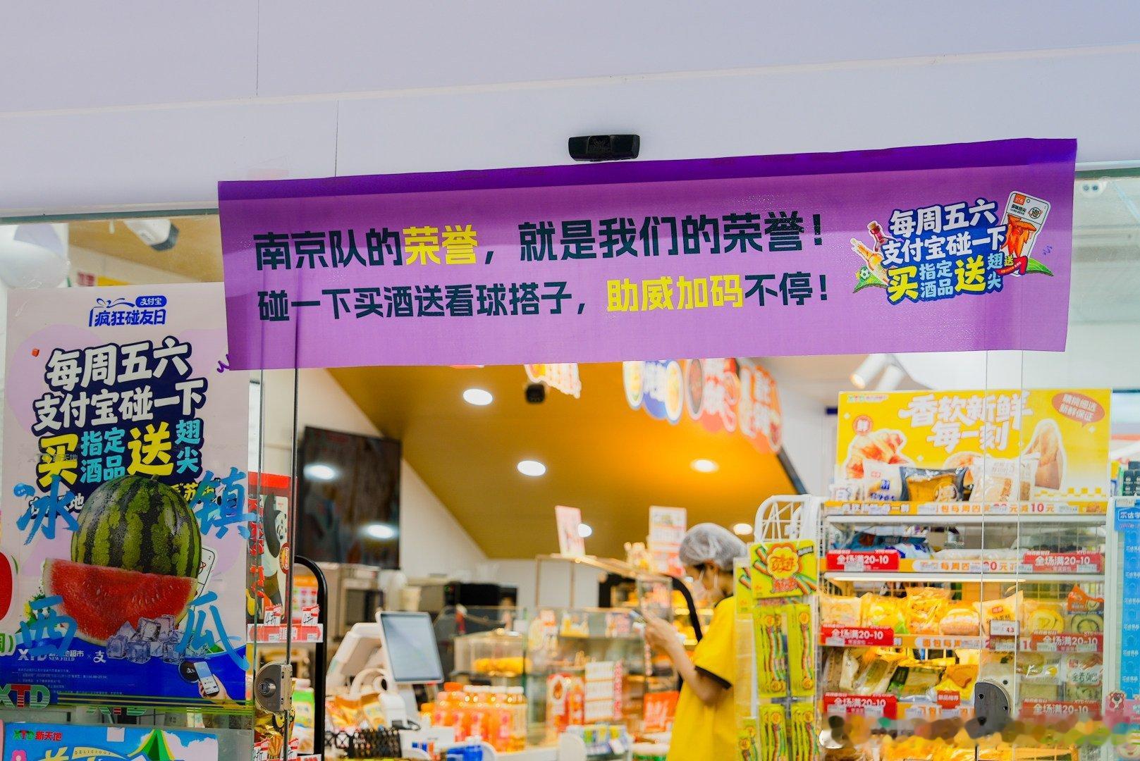 百店发支付宝助威袋为南京队加油便利店化身隐藏观球应援点，满墙南京队横幅，看得人瞬