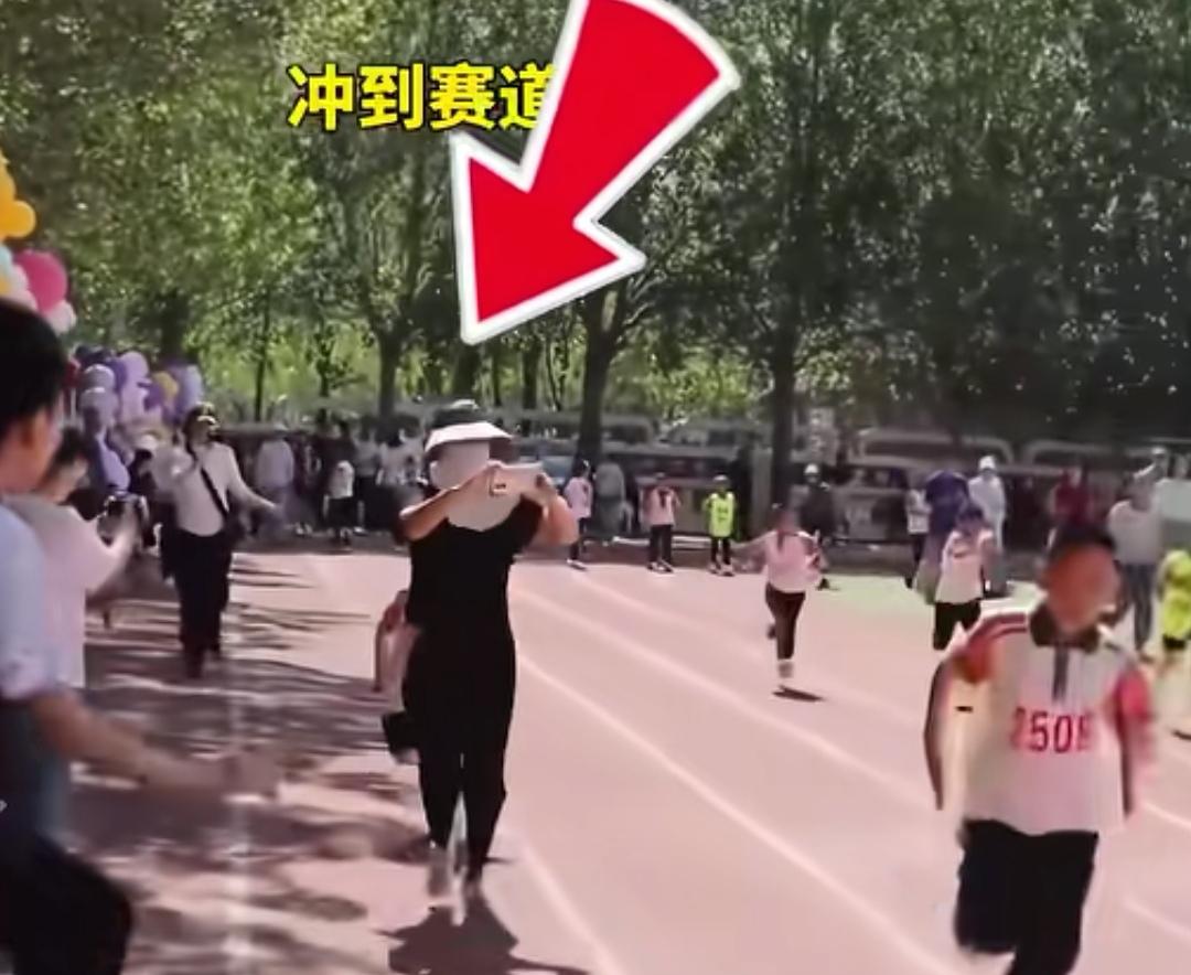5月29日，某校运动会，一名女子为给参赛儿子拍跑步视频，突然冲上跑道跟拍，多次挡