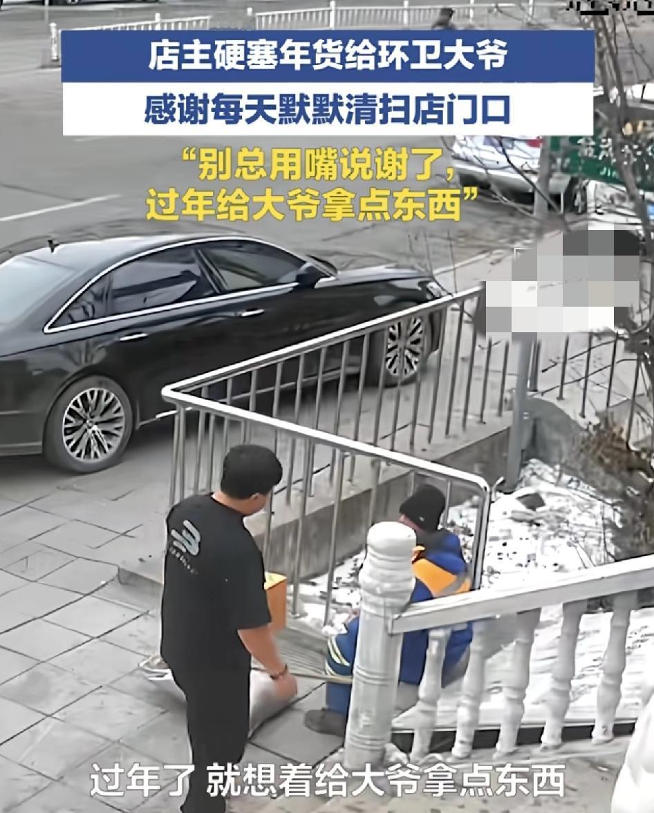 黑龙江牡丹江一位环卫大人正在街道清扫时，一位店主送来了年货。店主说非常感谢大爷平