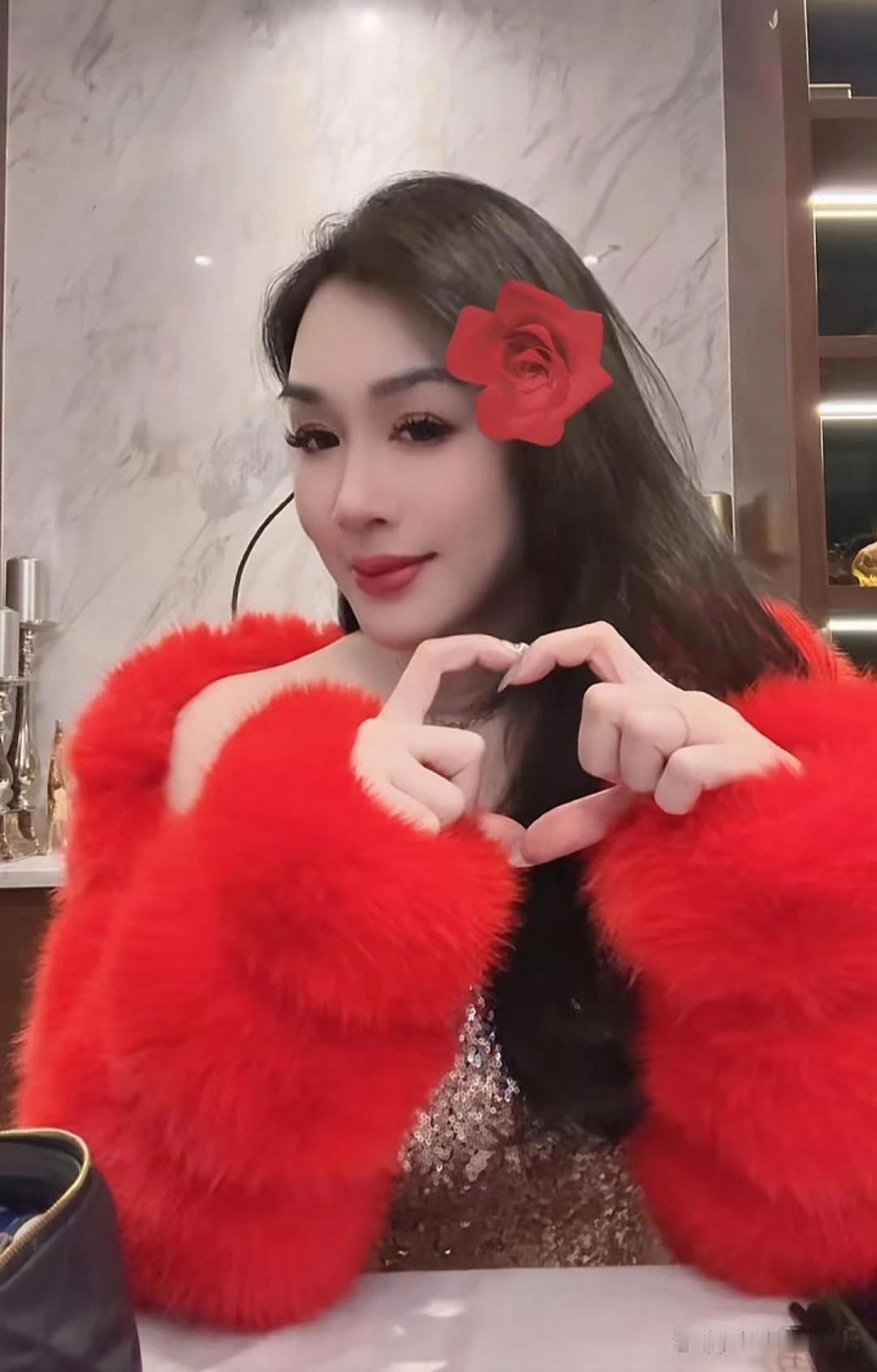 是钟丽缇模仿了王婆，还是王婆模仿了钟丽缇？帮别人说媒的，头上插一朵花还稍微能理解
