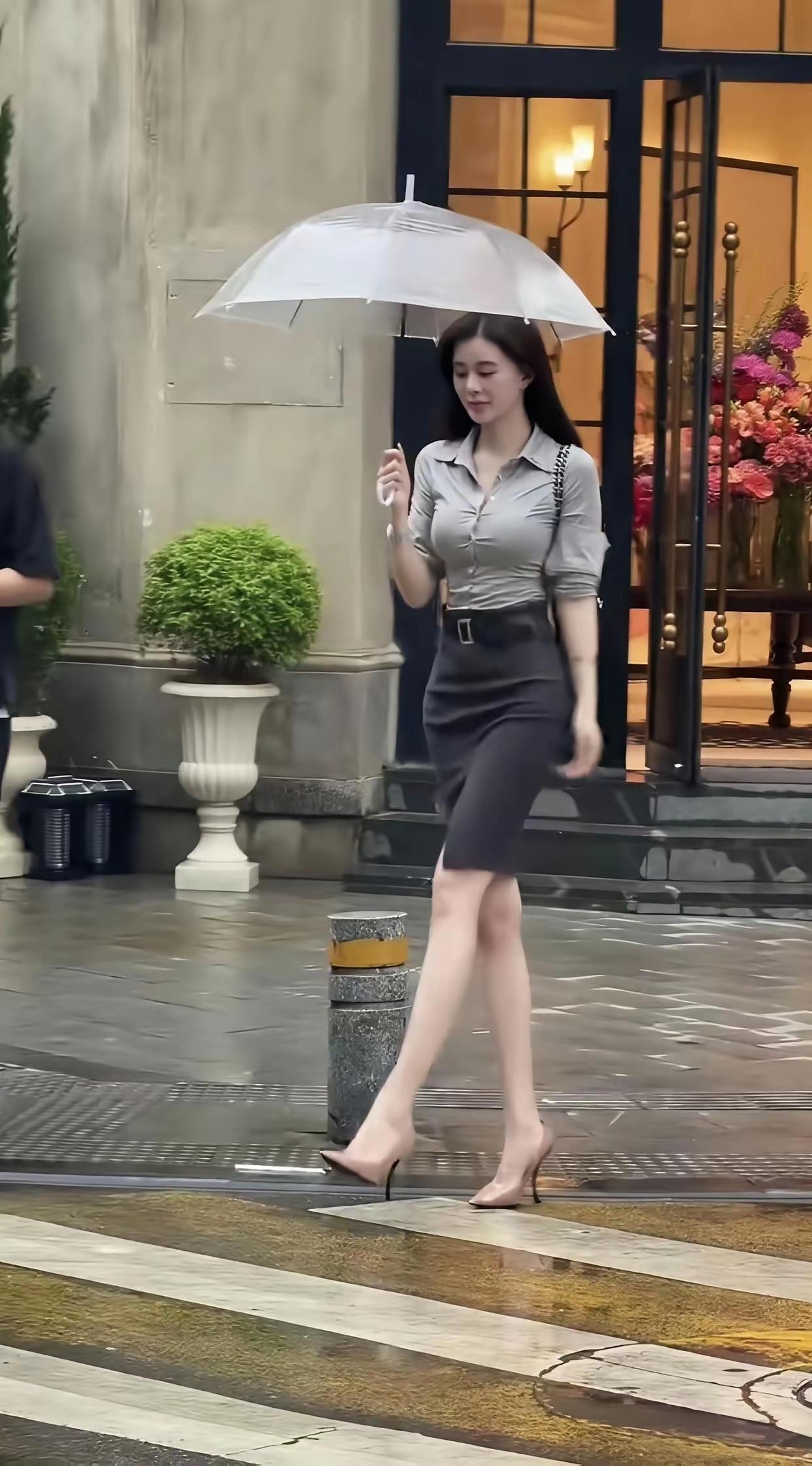细雨如丝，轻柔地飘洒在城市的每一寸土地，仿佛给世界蒙上了一层薄纱。她，一位优雅的
