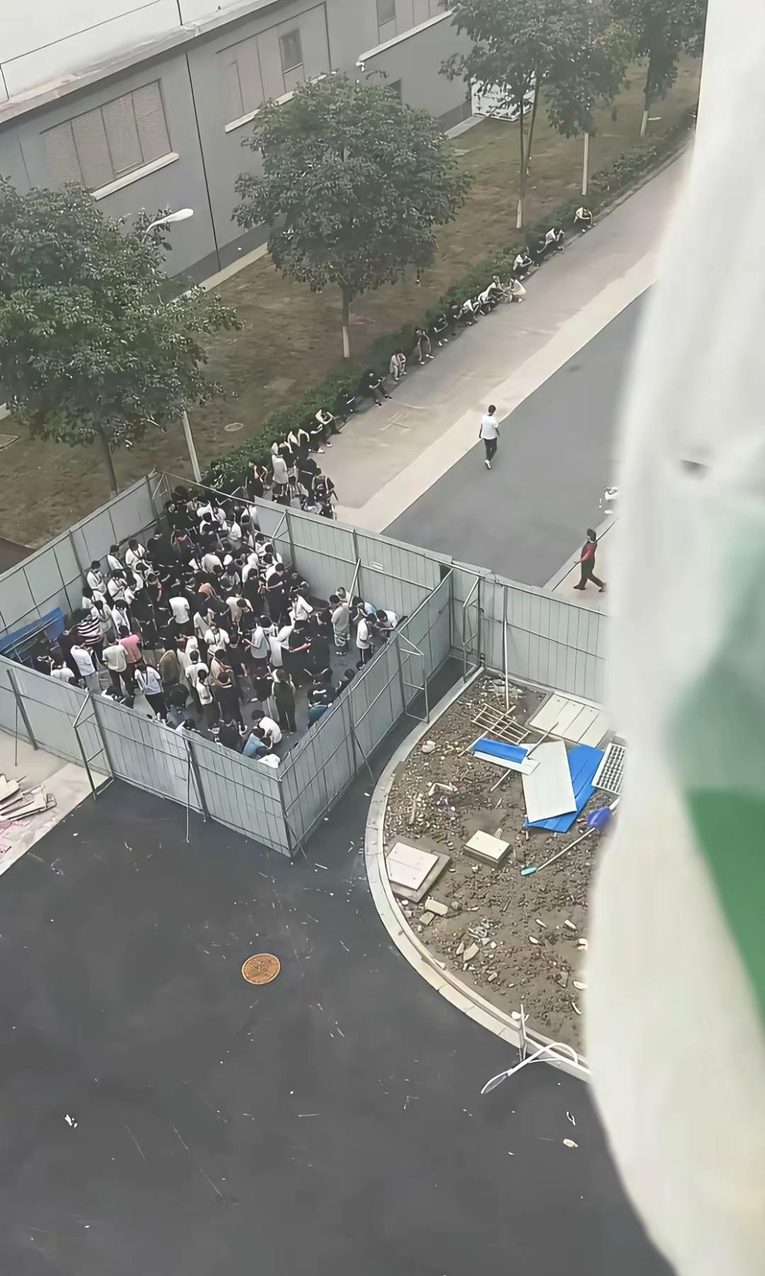 挺好奇，楼下这些人在干嘛？一打听才知道，原来是抽烟区。
竟然把抽烟区围成了一圈，