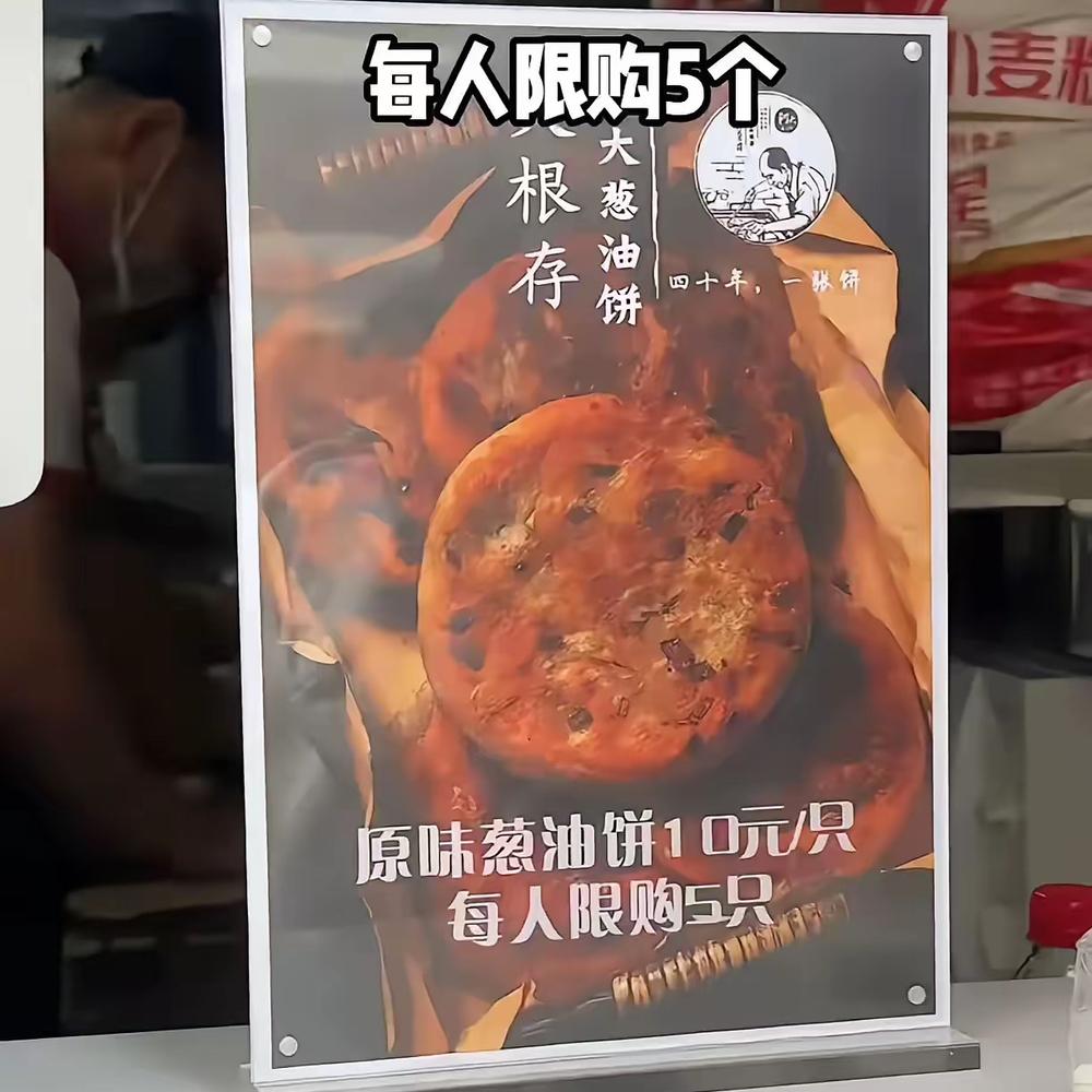 阿大坐在门口算是“精神领袖”，让食客错觉这饼和阿大还有点关系。
但是，看这儿子苦