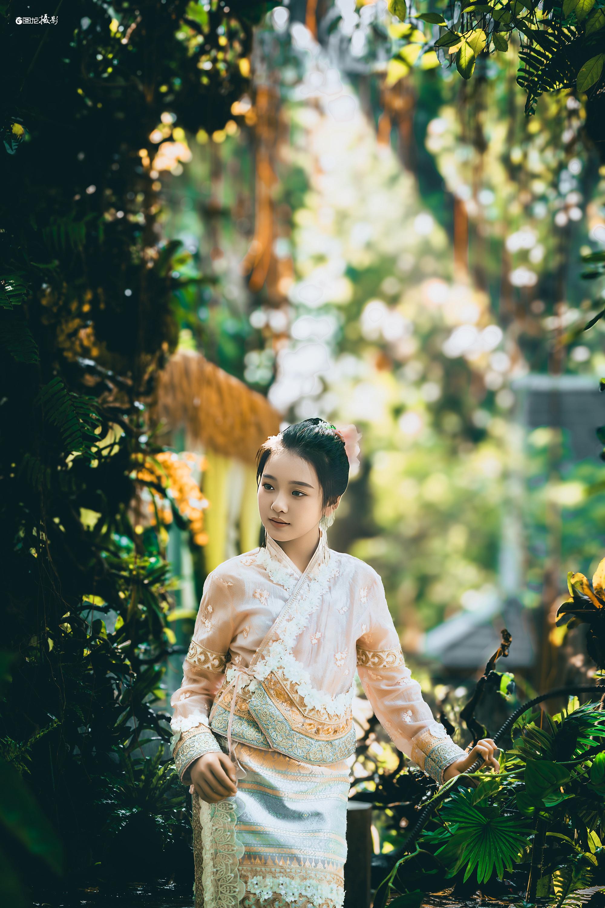 2023年在西双版纳的旅拍作品：阳光透过层层叠叠的枝叶洒下斑驳光影，身...