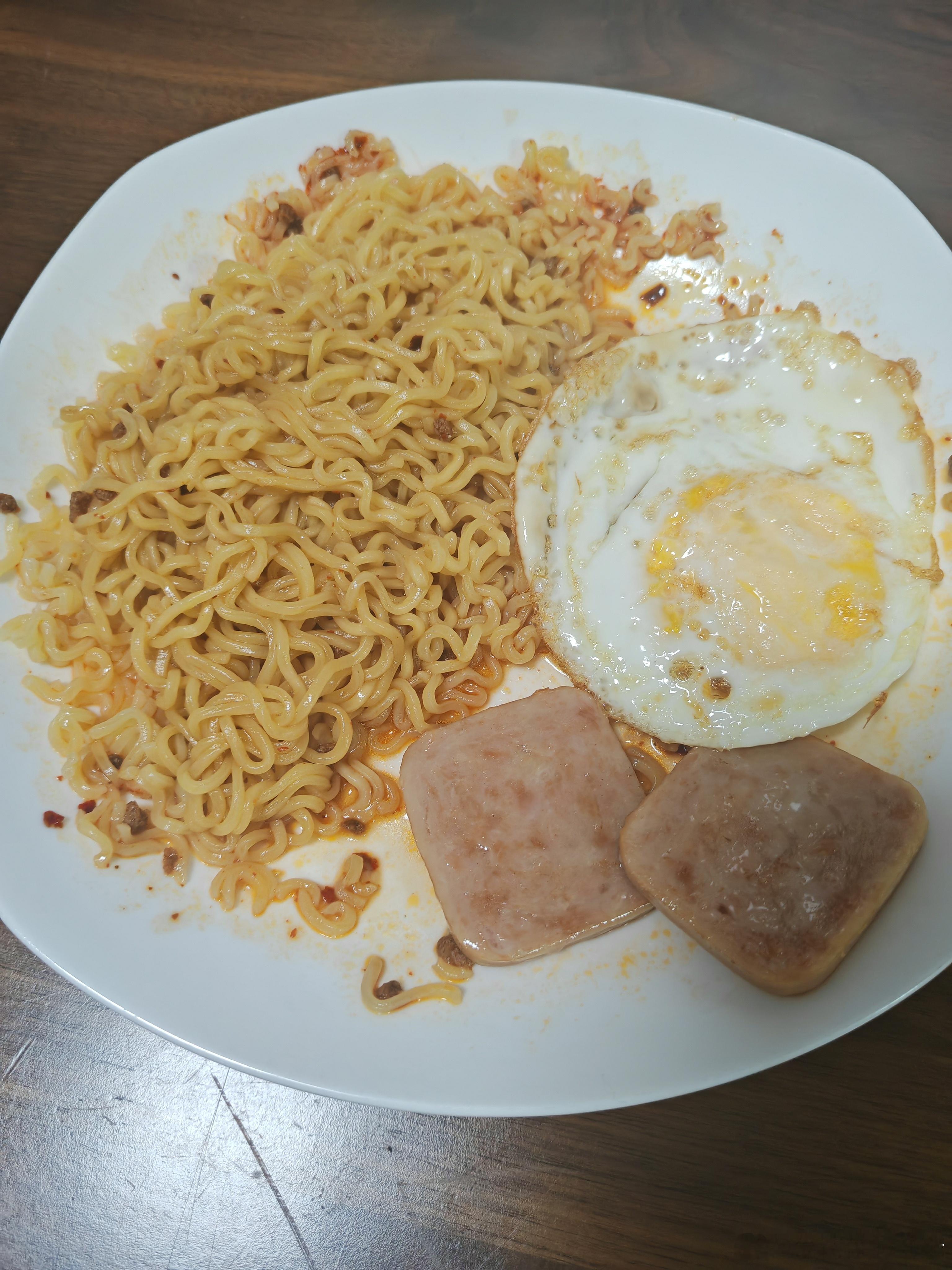 孩子早餐是印尼拌面，煎蛋，午餐肉。 