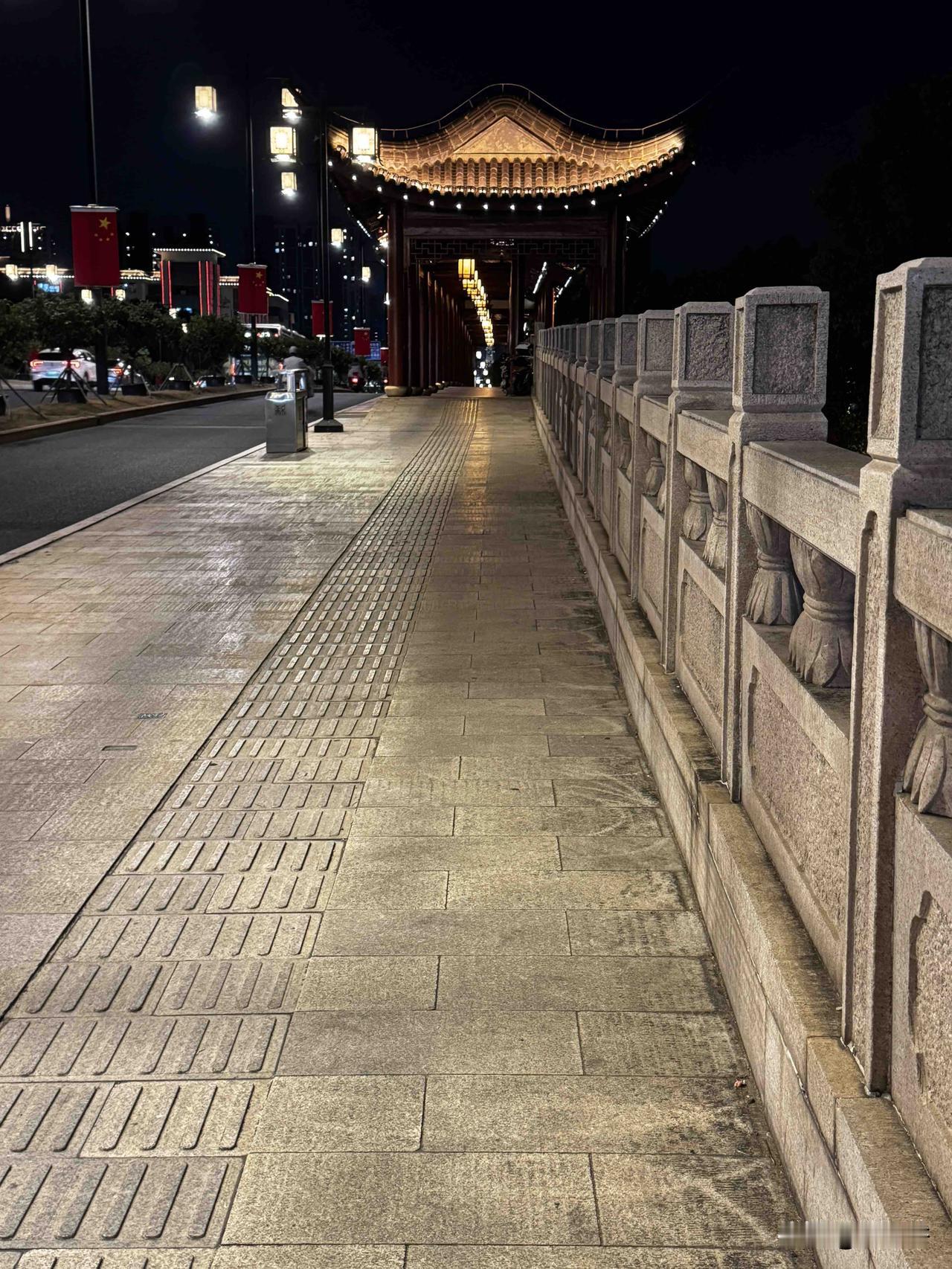 夜幕降临，苏州人民桥亮起灯火。石板步道，雕花石栏，远处飞檐流光。一边是都市车流，