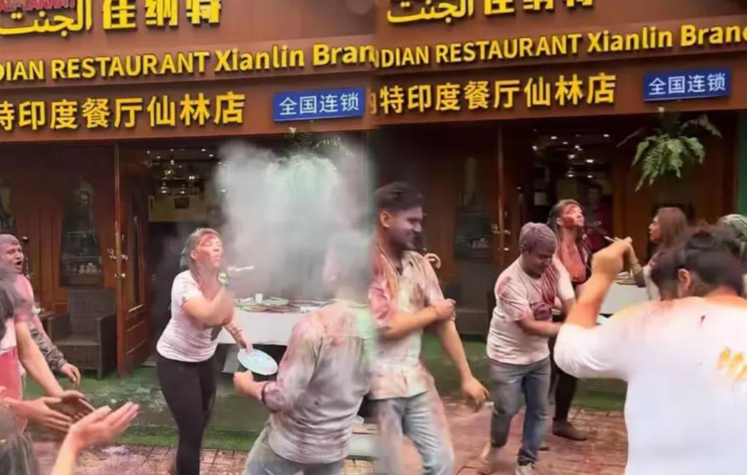 近日，南京仙林大学城，一家印度餐厅门口，20多名外籍人士在人行道上狂欢，说是过什