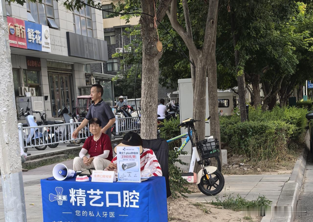 走过去后，才看清是口腔展销台。也许外面太热的缘故，一小姑娘躲在桌上的牌子后面，另