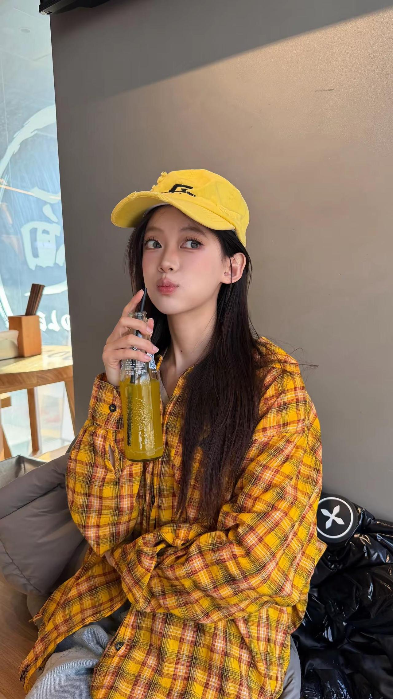 那个女孩 留着干枯的头发 穿着黄黄的衬衫。饮品穿搭