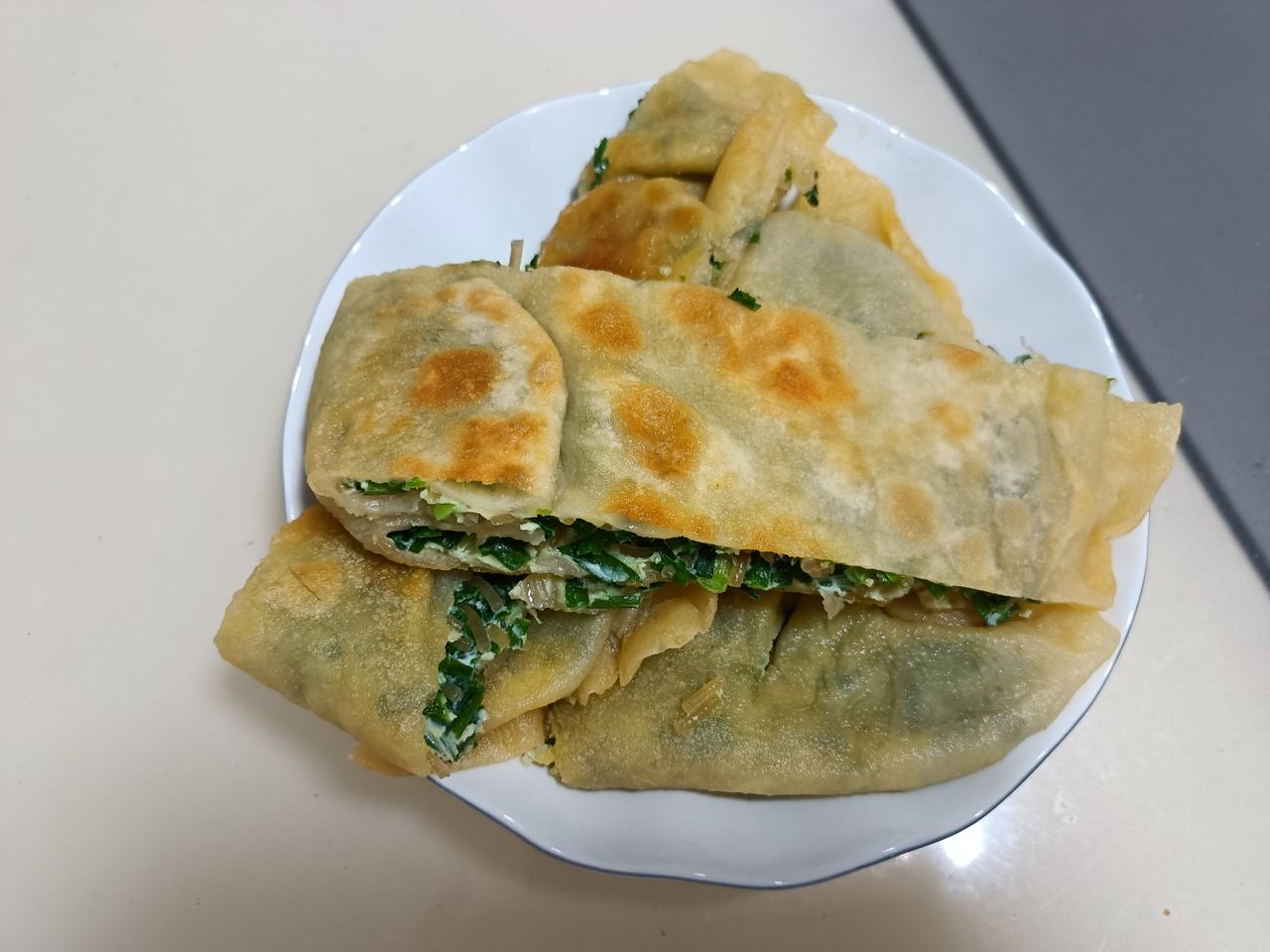 今天的午餐，韭菜盒子做好了，韭菜、粉条、鸡蛋馅的，外酥里嫩，咬一口嘎嘎香，非常好