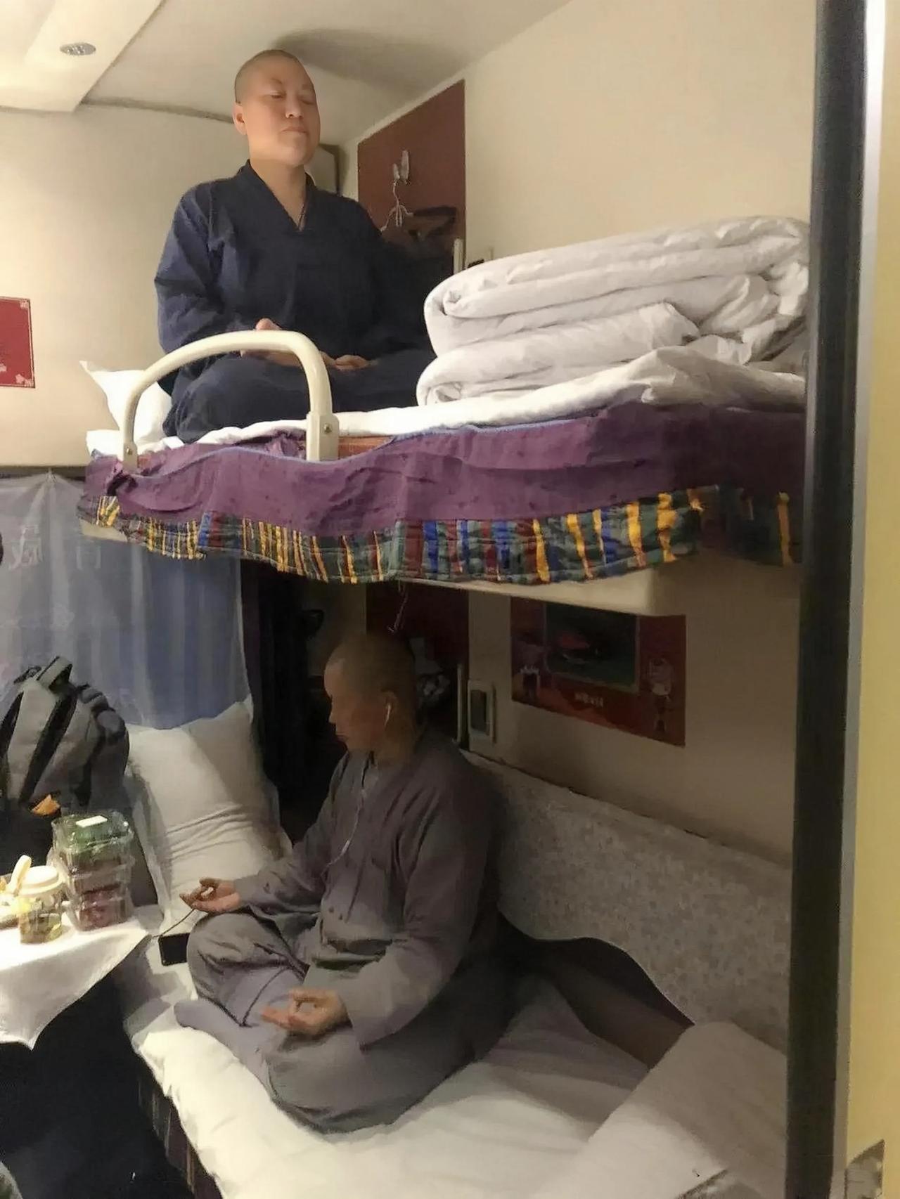 火车上的两个僧人，谁是真修行，谁是假修行，一目了然。
下铺的僧人戴着耳机，小桌上