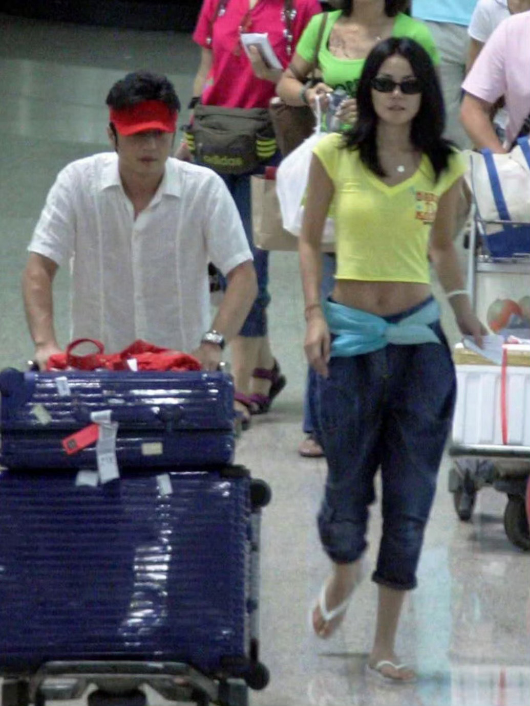 2005年的王菲和李亚鹏机场照，虽然已经怀着李嫣，但王菲露出的腹肌还是太惊艳了 