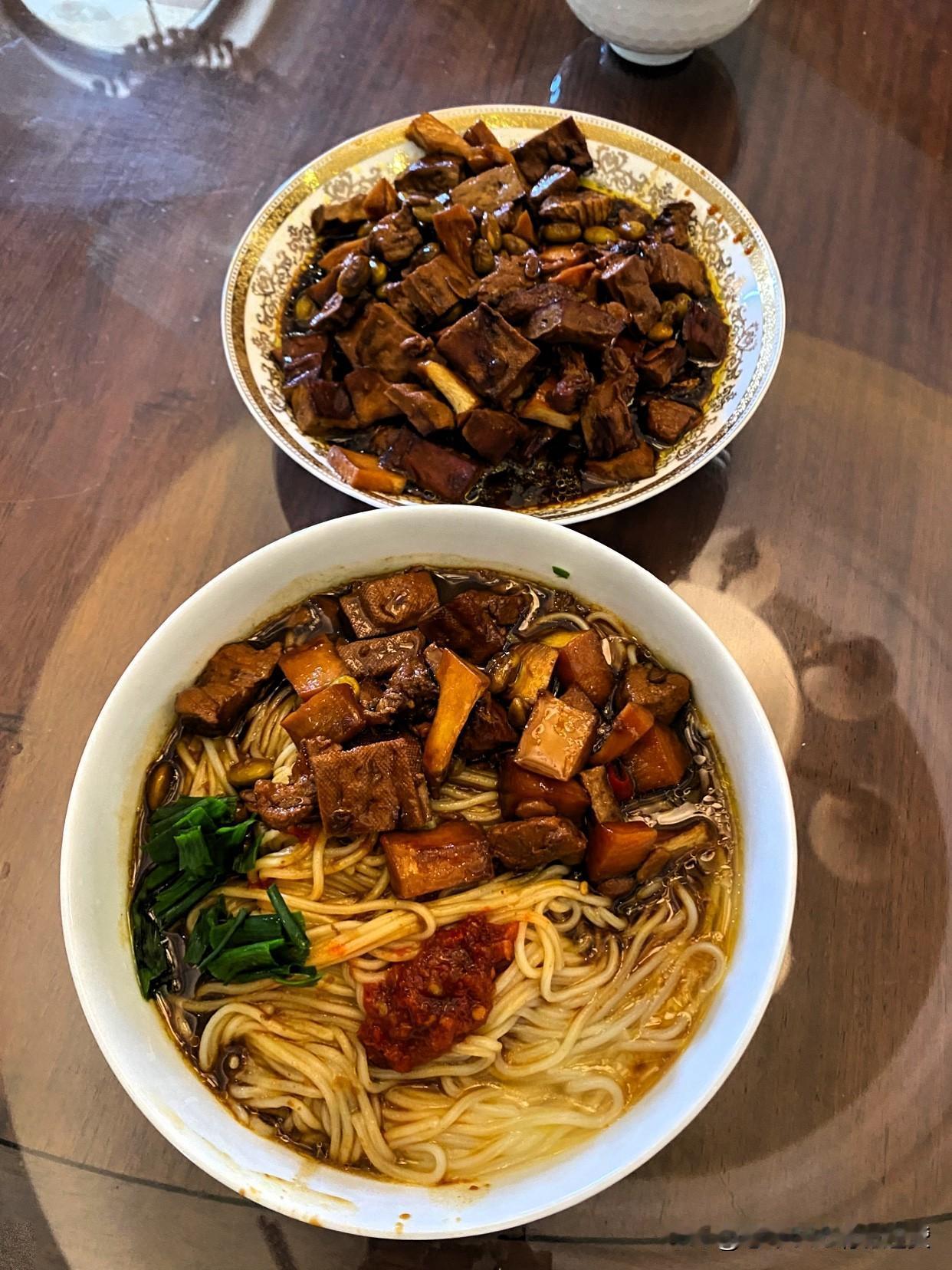回家把肉切成丁，起油锅放入老姜片和辣椒炒肉丁，放入剥去外壳的毛豆粒，茭白和豆腐干