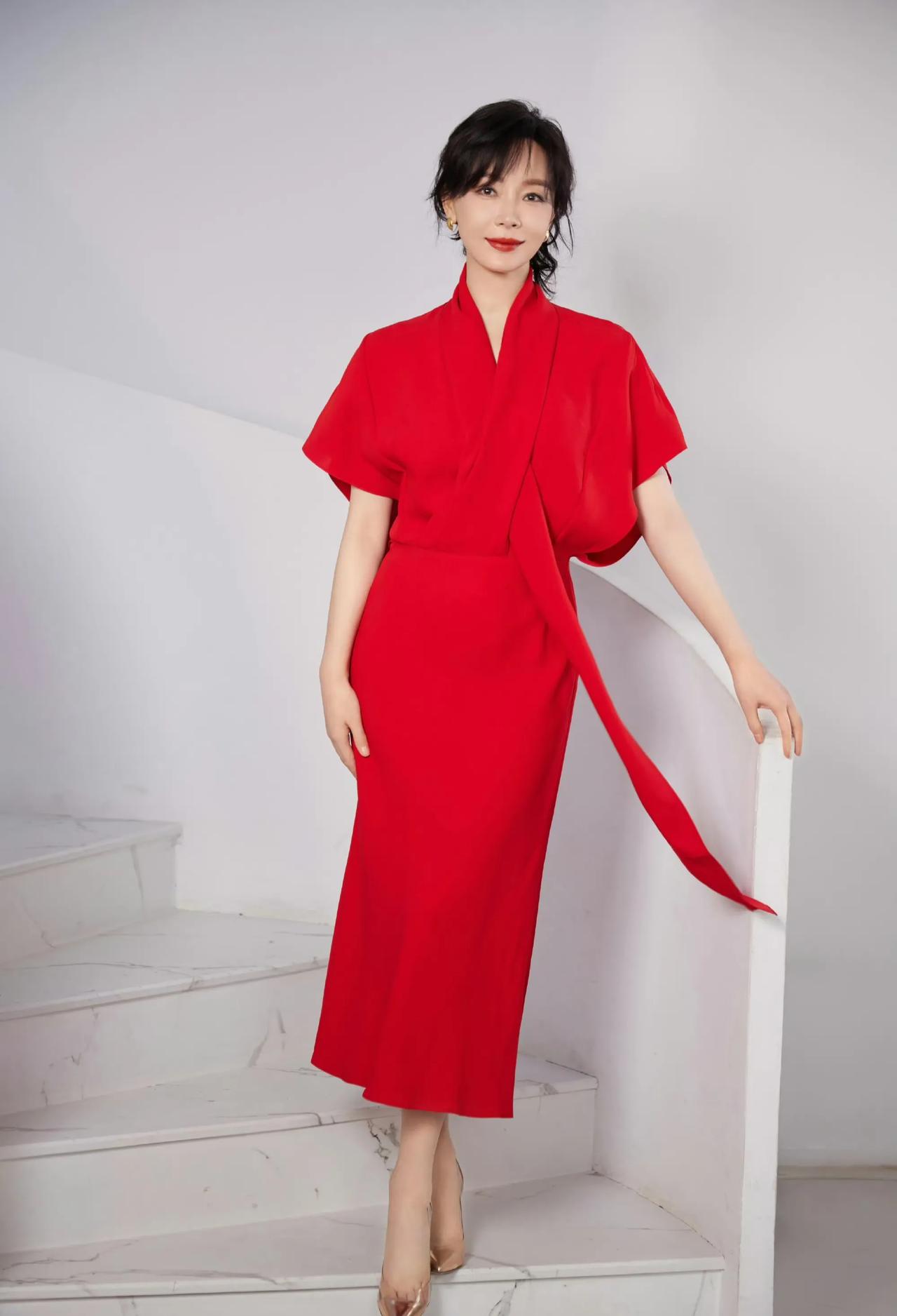 精致优雅的妆容，搭配上一身鲜艳的中国红长裙。脚穿着一双亮闪闪的高跟鞋！让她整个人