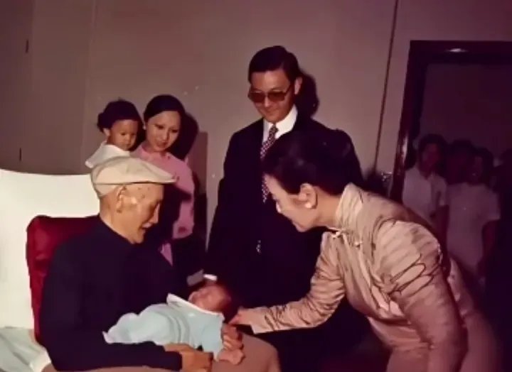 1973年，蒋介石怀抱刚满月的曾孙蒋友松，眼神中流露出深深的慈爱与宠溺。一旁的宋