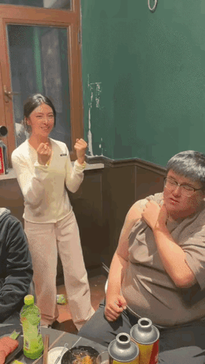 酒桌上男士为表达对异性朋友的歉意，把自己衣服撸到肩膀位置让她捶来解气，女生双手摆