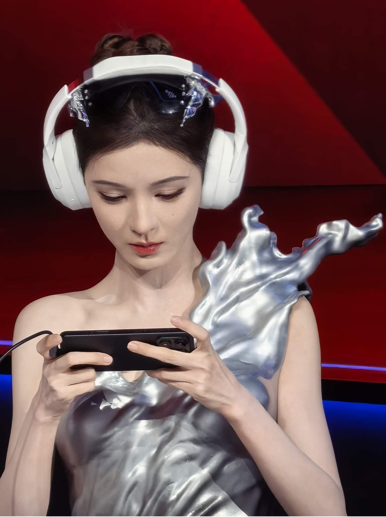 被张予曦在荣耀发布会现场打游戏的样子帅到了！12月26日的发布会上，她身着银黑礼