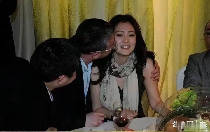 早年演员巩俐出席宴会时的一幕，不知道这位搂着她的男子是谁，让巩俐强颜欢笑，还挺尴