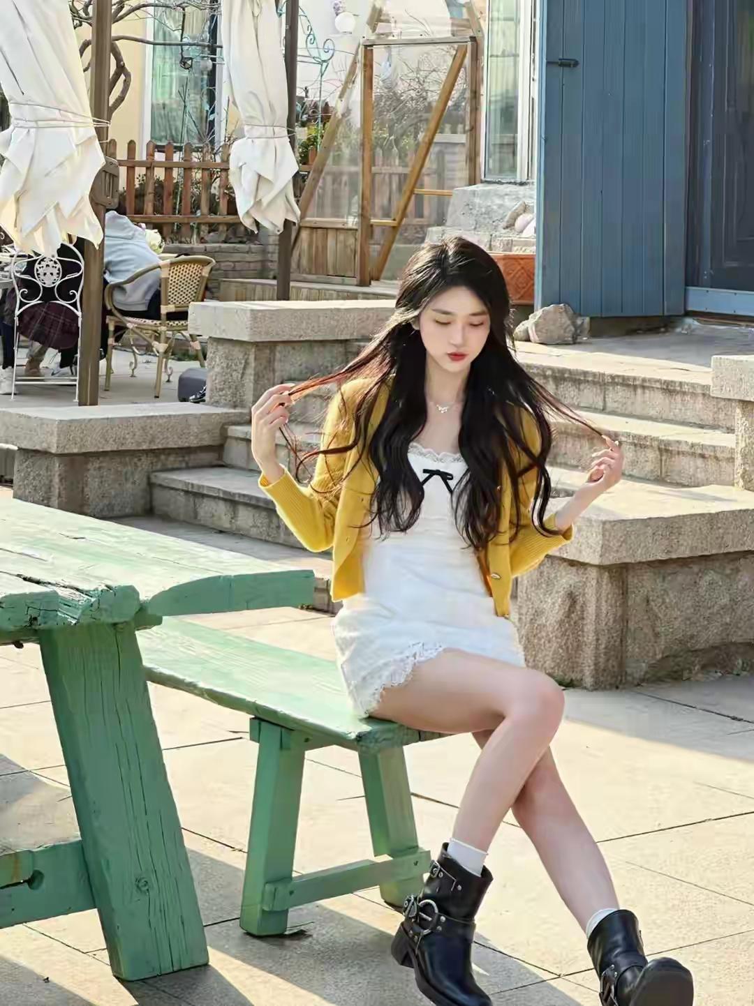 阳光下的野餐时光，穿着黄色外套的少女坐在绿桌旁，享受宁静的午后。女生为什么喜欢穿